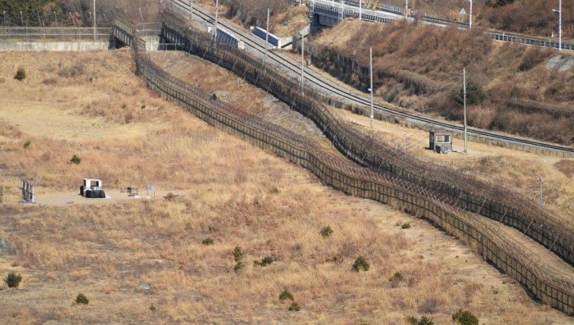 zone démilitarisée : vue panoramique d'une zone frontière avec des barbelés et drapeaux